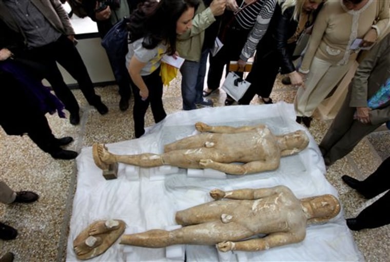 Two illegally excavated ancient male statues recovered from antiquities smugglers in southern Greece are displayed at the National Archaeological Museum in Athens on Tuesday.